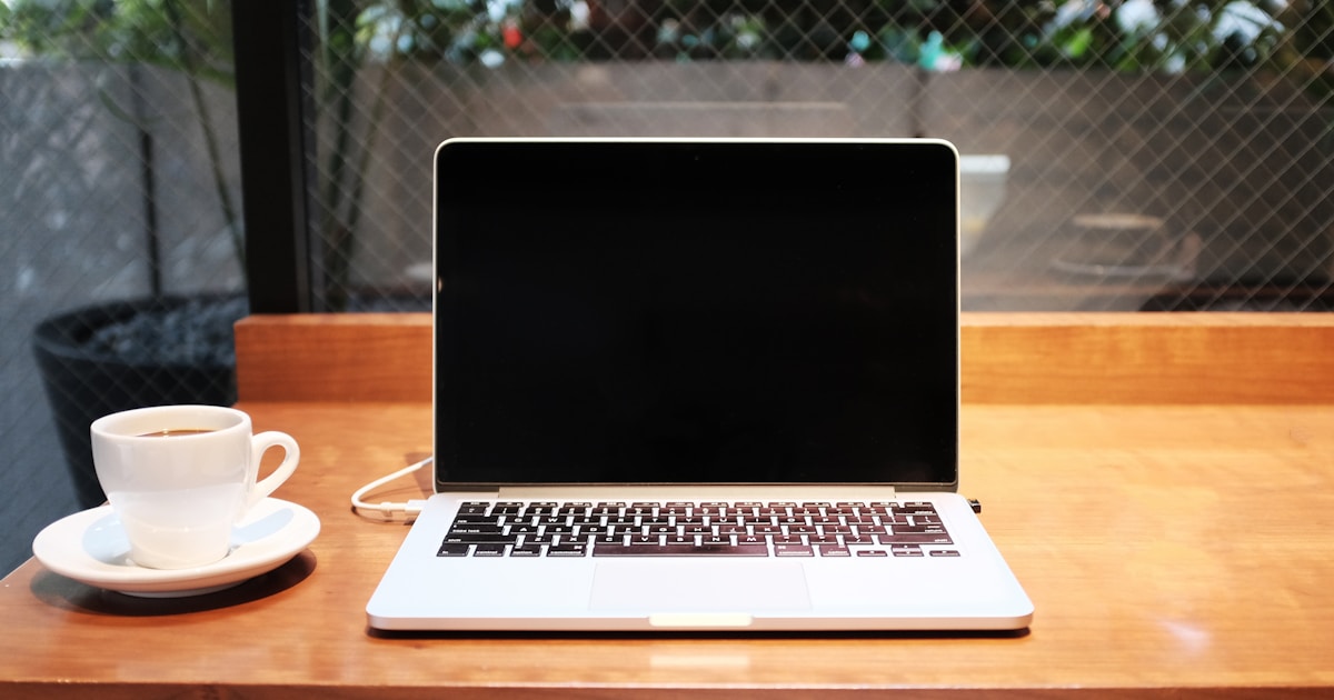 Laptop and coffee on a wooden desk